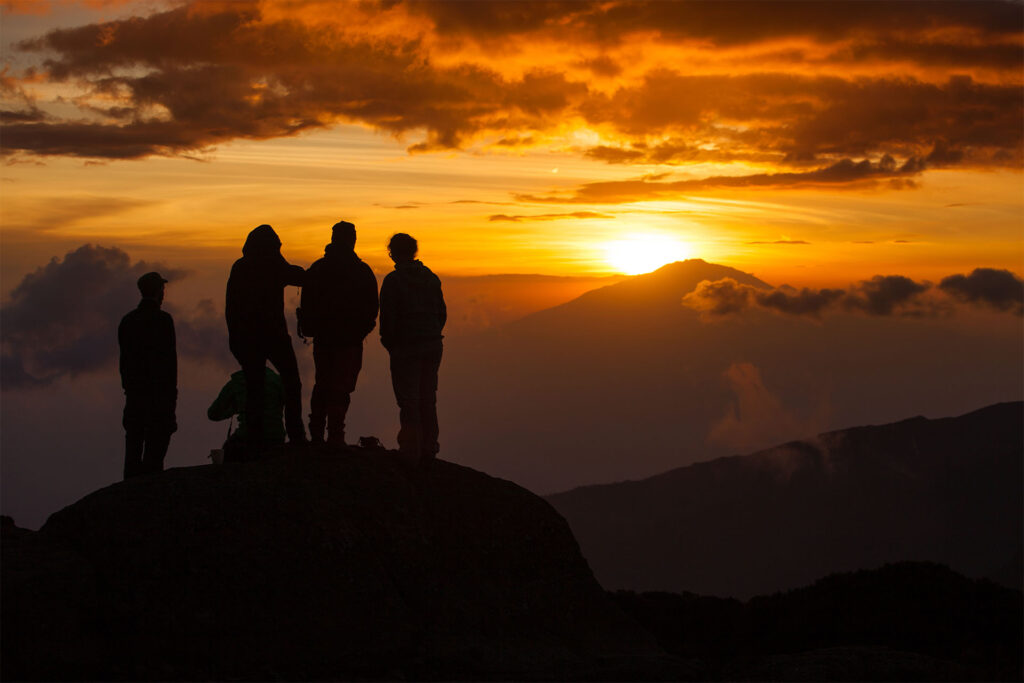 Bergsklättrare på toppen av Kilimanjaro i solnedgången