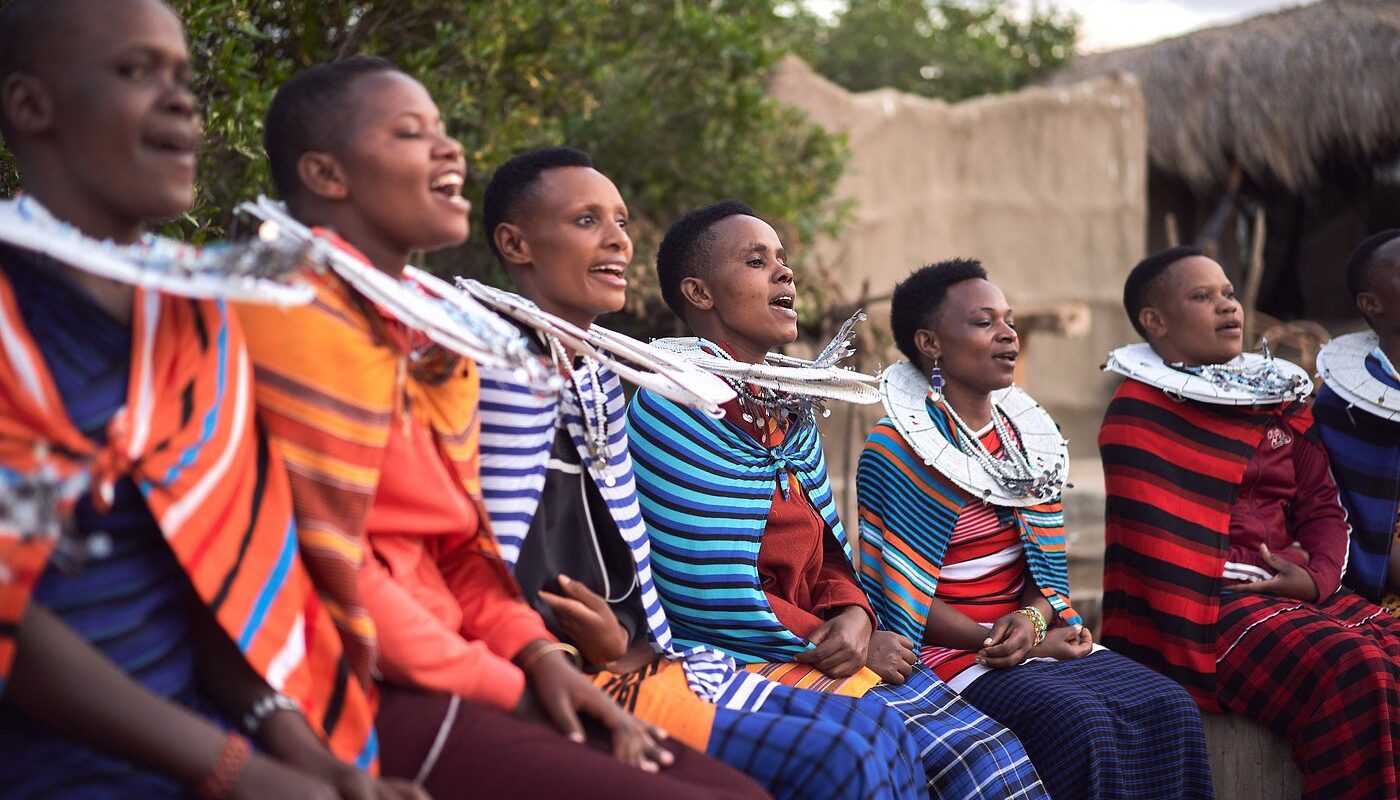 Massajer i färgstarka kläder vilar sittandes ner.