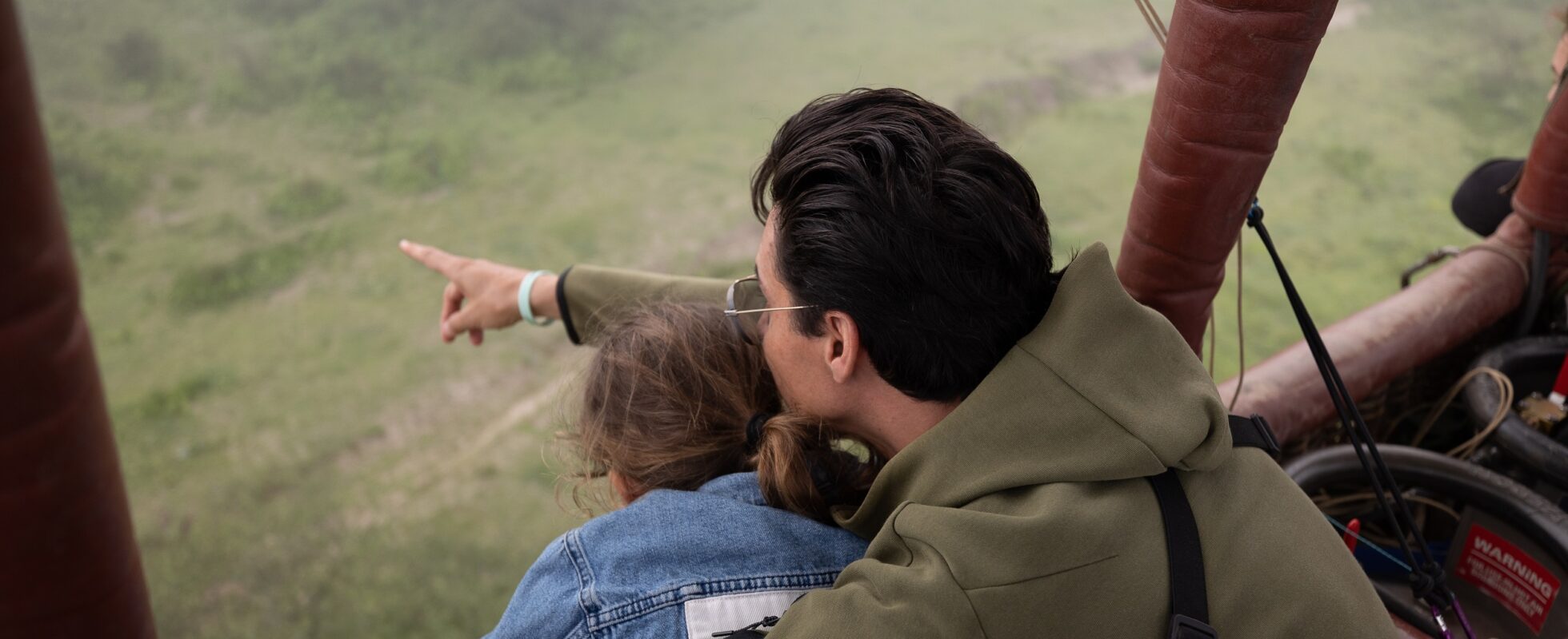 Två familjemedlemmar som letar efter djur från en luftballong i Serengeti, Tanzania.
